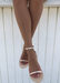 Model wearing aria rose gold jelly sandals crossed at the ankles