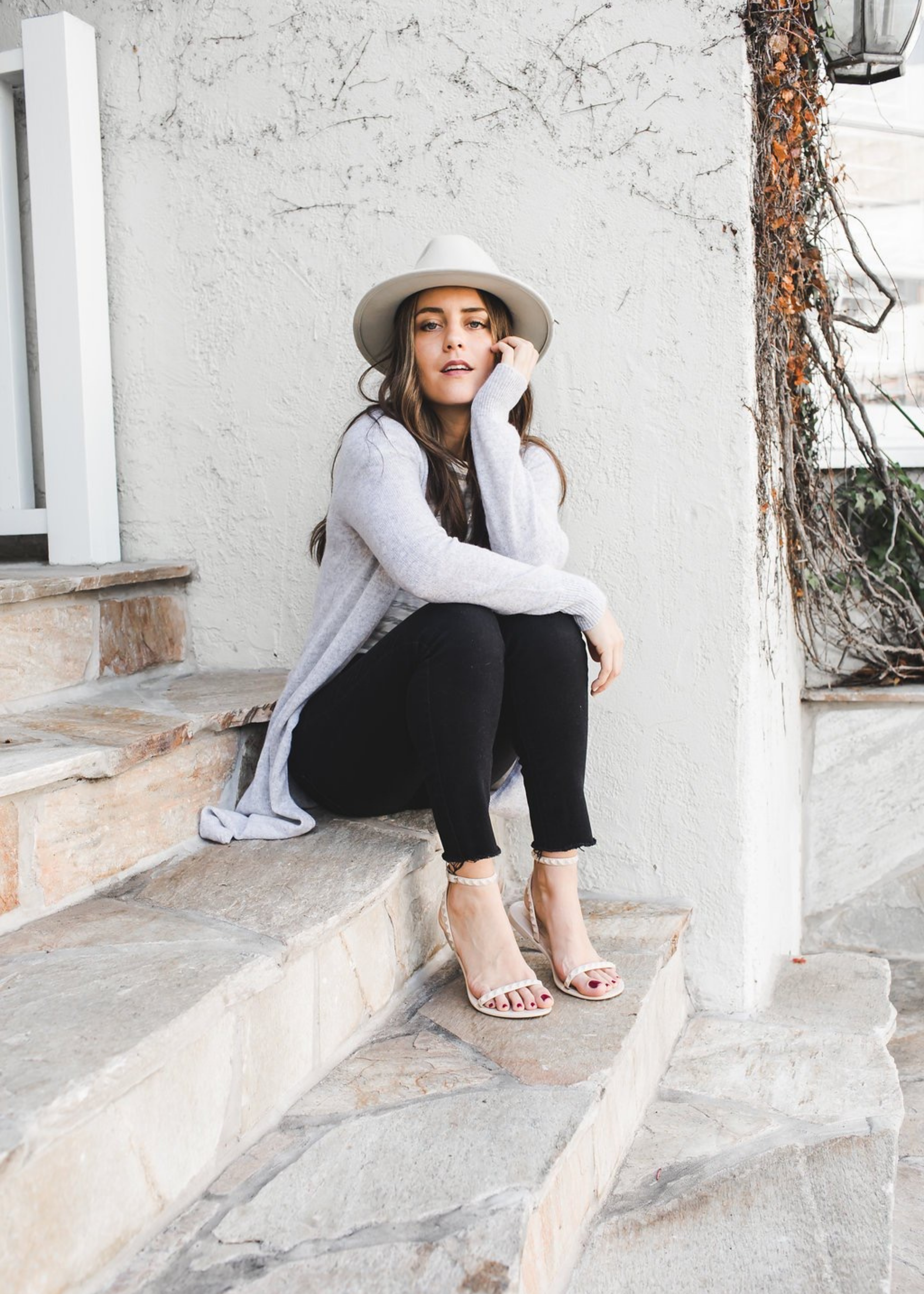 @karla_jordan3 sitting down  wearing Aria sandals in Nude and a cute stylish outfit.