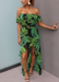 Model posing wearing a tropical green palm print dress and Aria sandals in Black.