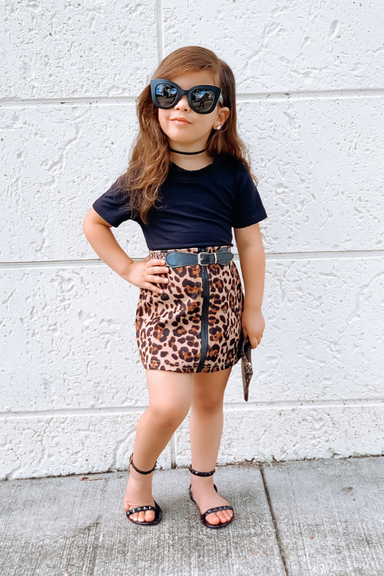 TODDLER GIRL WEARING ANIMAL PRINT SKIRT PAIRED WITH SHOES BY Alexandria Brandao BLACK JELLY STRAP SANDALS FOR KIDS AND GIRLS. MOMMY AND ME MATCHING SANDALS FOR MOMMY AND ME AND MOTHER DAUGHTER FALL OUTFITS