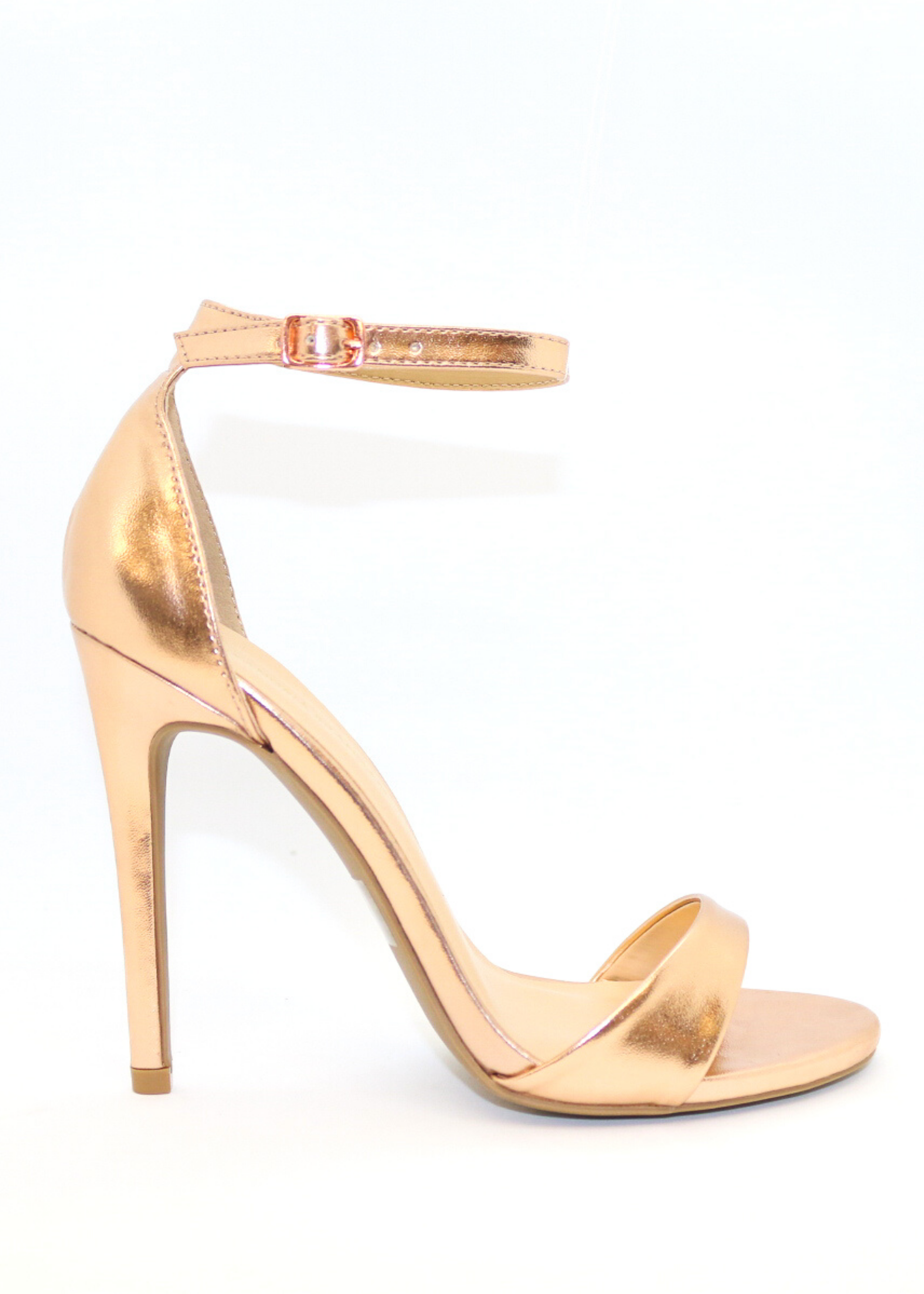 ALI heel in rose gold that is pictured from above and picturing side view and marble top as the background for better view. Ali Heels in rose gold that has a buckle on the ankle and cover heel in the back as well as thick to thin and thick again for secure and comfort.