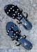 Aurora Black Jelly sandal that has  Gold Studs on all straps and is a slip on sandal.  Sandal has three equally separated horizontal straps that goes all the way to top of the bridge of the foot and one strap in the middle connecting all straps