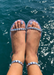 Aria silver waterproof jelly sandals with the oceanin the background