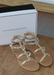 Ava sandals in Nude with Gold studded details on a wood table. 